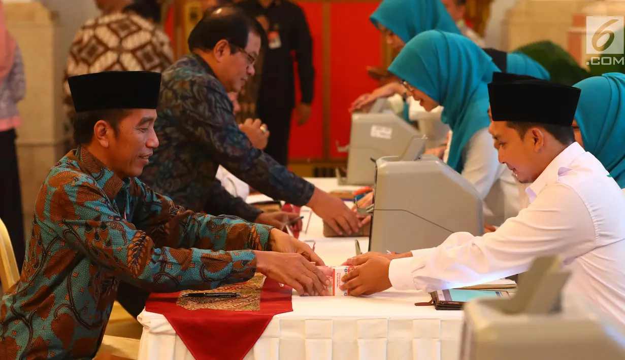 Presiden Joko Widodo (kiri) menyerahkan zakat mal kepada petugas Badan Amil Zakat Nasional (Baznas) di Istana Negara, Jakarta, Kamis (16/5/2019). Jokowi menyerahkan zakat penghasilan senilai Rp 55 juta secara tunai. (Liputan6.com/Angga Yuniar)