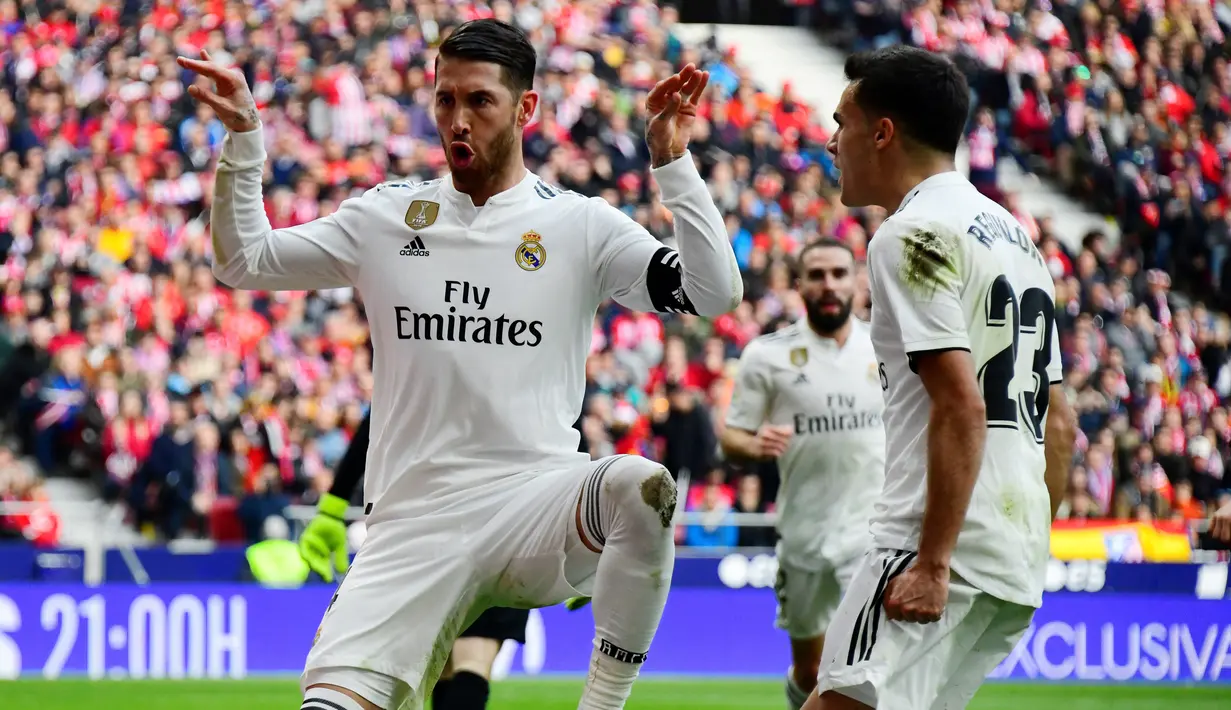 Bek Real Madrid, Sergio Ramos (kiri) berselebrasi usai mencetak gol ke gawang Atletico de Madrid pada pertandingan lanjutan La Liga Spanyol di stadion Wanda Metropolitano (9/2). Real Madrid menang 3-1 atas Atletico. (AFP Photo/Gabriel Bouys)