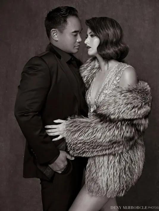 Berfoto bersama sang suami, Nia Ramadhani menunjukkan potret mesra dengan merangkul pinggang Ardi Bakrie. Ardi sendiri mengenakan kemeja hitam dengan setelan jas berwarna senada. (instagram/denymirrorcle)