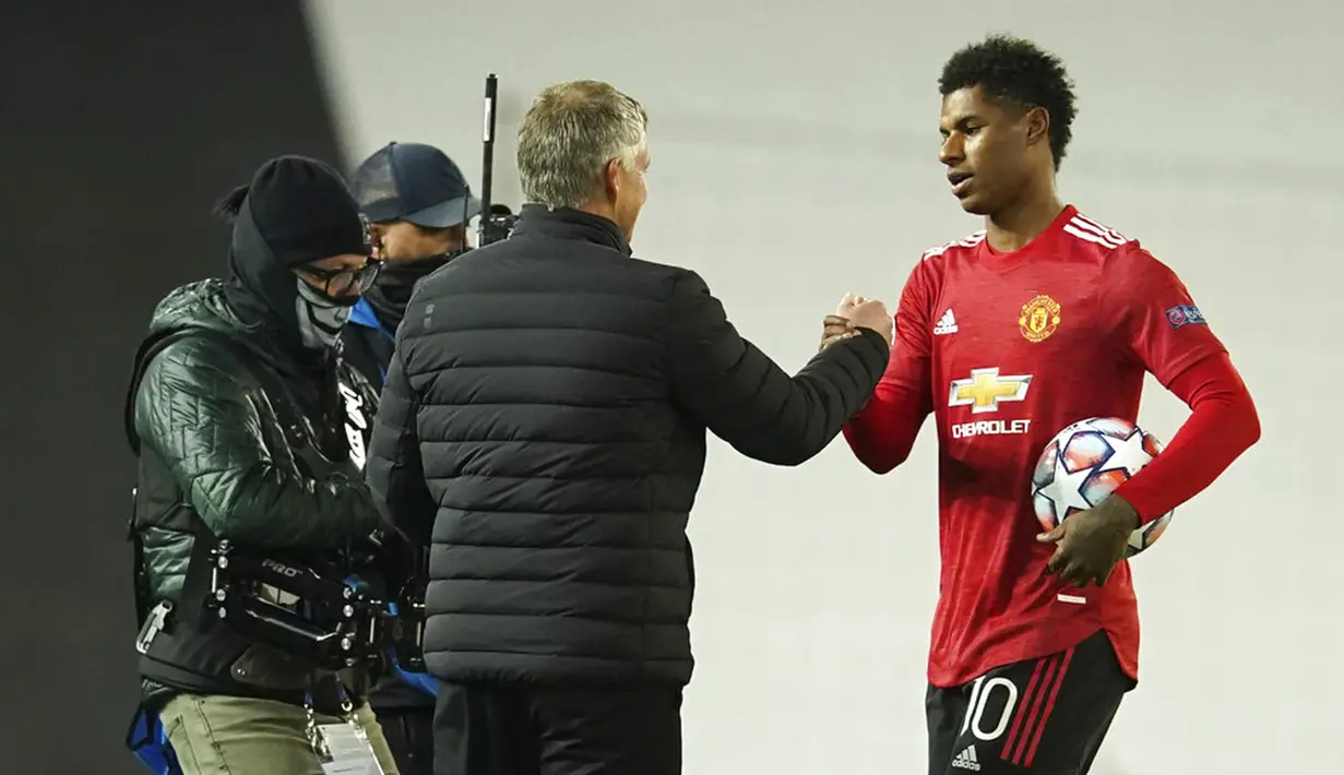 Manajer Manchester United Ole Gunnar Solskjaer (kiri) menyemangati pemainnya Marcus Rashford pada akhir pertandingan Grup H Liga Champions di Stadion Old Trafford, Manchester, Inggris, Rabu (28/10/2020. Manchester United menang 5-0, Marcus Rashford cetak hattrick. (AP Photo/Dave Thompson)