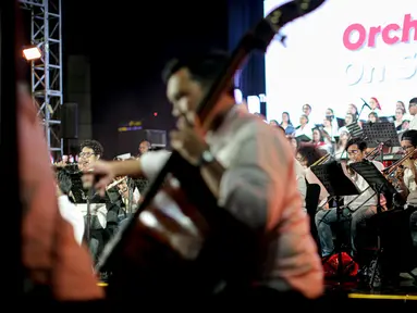 Komposer Addie MS tampil bersama kelompok musik simfoni Twilite Orchestra pada acara Orchestra On Station di Stasiun BNI City, Jakarta, Jumat (16/9/2022). Pertunjukan diselenggarakan dalam rangka rangkaian HUT PT Kereta Commuter Indonesia (KCI) ke -14. (Liputan6.com/Faizal Fanani)