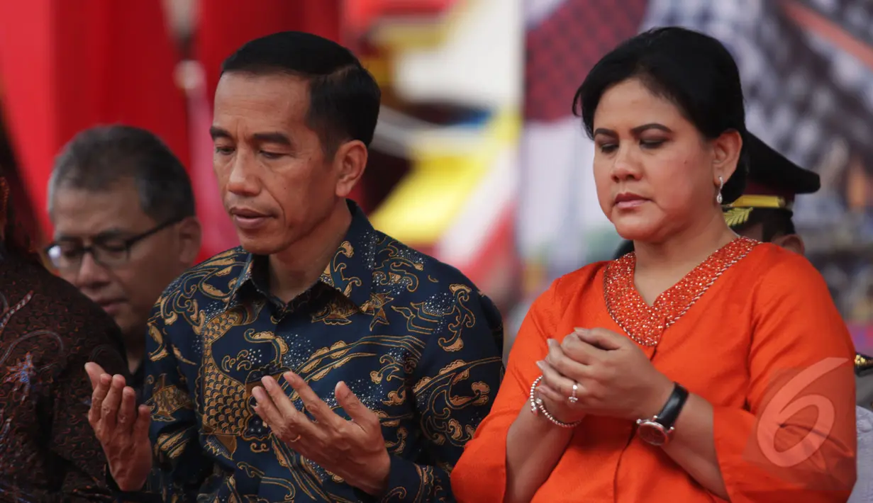 Presiden Joko Widodo didampingi Iriana Widodo saat menghadiri perayaan Cap Go Meh di Kota Bogor, Jawa Barat, Kamis (5/3/2015). Keduanya tampak mengangkat kedua tangan saat pembacaan doa (Liputan6.com/Faizal Fanani)