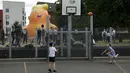 Aktivis mengembangkan balon berbentuk bayi Presiden AS Donald Trump di Bingfield Park, London, 10 Juli 2018. Balon setinggi enam meter atau 19 kaki itu akan diterbangkan dekat dengan Parlemen Inggris selama kunjungan Presiden Trump.  (AP /Matt Dunham)