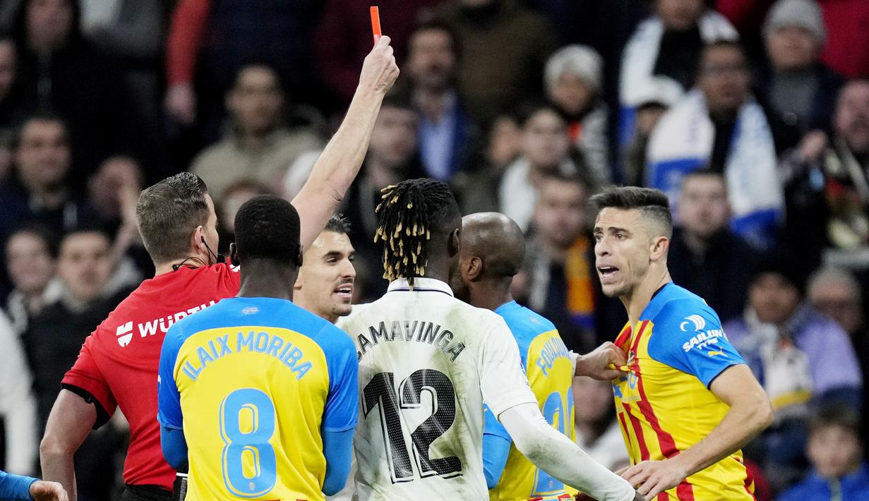 Wasit Javier Alberola Rojas memberikan kartu merah kepada pemain Valencia, Gabriel Paulista saat melawan Real Madrid pada laga Liga Spanyol di Stadion Santiago Bernabeu, (2/2/2023). Kemenangan ini menjaga jarak Madrid dengan Barcelona di papan atas tetap lima angka. Bagi Valencia, mereka harus tetap tertahan di peringkat ke-14 dengan 20 poin. (AFP/Javier Soriano)