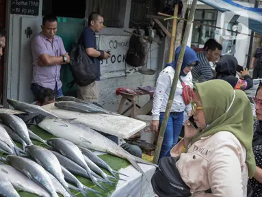 Pedagang ikan bandeng melayani pembeli di kawasan Rawa Belong, Jakarta, Selasa (21/1/2020). Bandeng yang biasanya menjadi hidangan khas saat Tahun Baru Imlek tersebut mulai ramai diperdagangkan di Rawa Belong. (Liputan.com/Faizal Fanani)