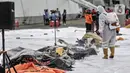 Petugas PMI menyemprotkan disinfektan pada hasil temuan dari pencarian Sriwijaya Air SJ 182 di Dermaga JICT 2, Jakarta, Minggu (10/1/2021). Penyemprotan rutin untuk mengantisipasi penyebaran COVID-19 dilakukan usai hasil temuan diidentifikasi tim DVI serta KNKT. (merdeka.com/Iqbal S. Nugroho)