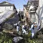 Petugas pemadam kebakaran berjalan melewati rumah-rumah yang roboh akibat gempa bumi di Suzu, prefektur Ishikawa, Jepang, Kamis (4/1/2024). (Kyodo News via AP)