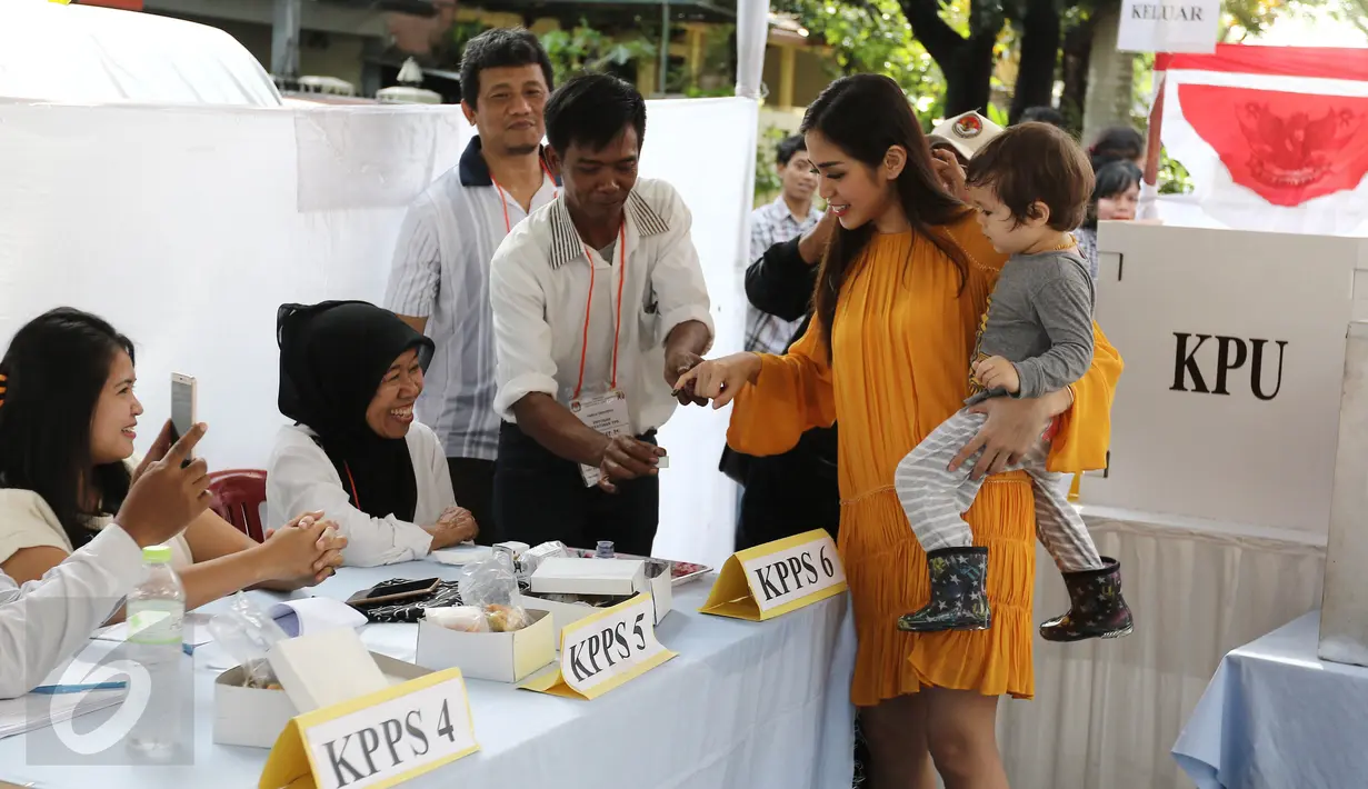 Aktris Jessica Iskandar  memasukan tangan ke tinta untuk mengikuti Pilkada serentak di TPS 22 jalan Bukti Tunggul, Setia Budi, Jakarta, Rabu (15/2). (Liputan6.com/Herman Zakharia)