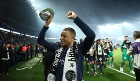 Penyerang Paris Saint-Germain, Kylian Mbappe merayakan dengan trofi juara Ligue 1 Prancis di stadion Parc des Princes, Paris pada 12 Mei 2024. (FRANCK FIFE/POOL/AFP)