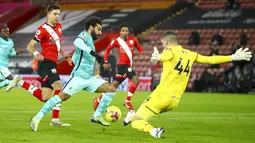 Kiper Southampton Fraser Forster (kanan) memblok tembakan ke gawang dari pemin Liverpool Mohamed Salah pada pertandingan Liga Inggris di St Mary's Stadium, Southampton, Inggris, Senin (4/1/2021). Southampton menang 1-0 atas Liverpool. (AP Photo/Michael Steele,Pool)