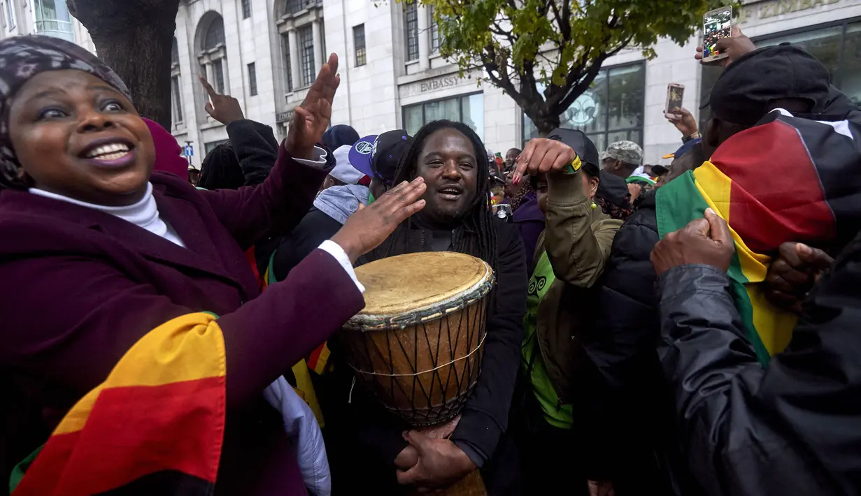 Warga Zimbabwe yang menetap di Inggris menggelar aksi protes di luar Kedutaan Besar Zimbabwe di London, Sabtu (18/11). Tak hanya menggelar long march, mereka juga menari dan minum bersama sambil menyerukan teriakan agar Mugabe mundur. (NIKLAS HALLE'N/AFP)