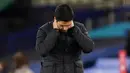 Pelatih Arsenal, Mikel Arteta, tertunduk lesu usai ditaklukkan Everton pada laga Liga Inggris di Stadion Goodison Park, Minggu (20/12/2020). Everton menang 2-1 atas Arsenal. (AFP/Jon Super, Pool)