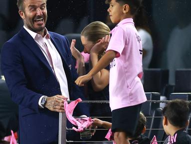Reaksi pemilik klub Inter Miami, David Beckham (kiri) saat anak dari Lionel Messi dan Sergio Busquets mencipratkan air sebelum laga Inter Miami melawan Orlando City pada laga lanjutan MLS Amerika di DRV PNK Stadium, Florida, Amerika Serikat, 2 Agustus 2023 waktu setempat. (AFP/Getty Images/Hector Vivas)