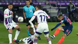 Striker Sevilla, Papu Gomez (kanan) melepaskan tendangan yang masih membentur pemain Real Valladolid dalam laga lanjutan Liga Spanyol 2020/2021 pekan ke-28 di Jose Zorrilla Stadium, Valladolid, Sabtu (20/3/2021). Sevilla bermain imbang 1-1 dengan Valladolid. (AFP/Cesar Manso)