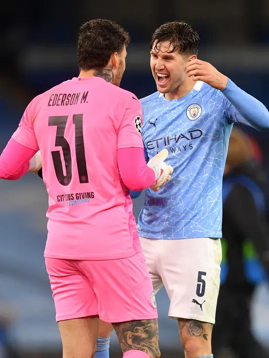 Kiper Manchester City, Ederson (kiri) dan bek John Stones merayakan kemenangan atas PSG pada leg kedua semifinal Liga Champions di stadion Etihad, Rabu (5/5/2021). City menang atas PSG 2-0. (AFP/ Paul Ellis)