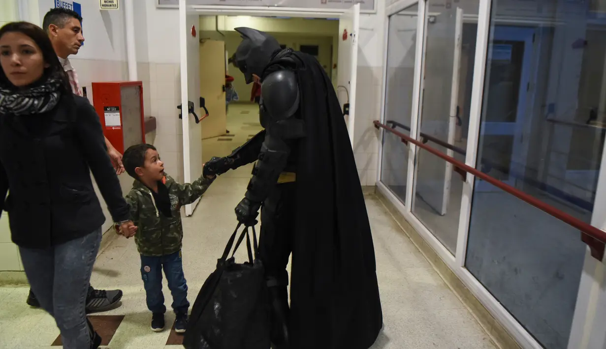Pria berkostum Batman menyapa seorang anak di RS Anak 'Sor Maria Ludovica' di La Plata, Buenos Aires, Argentina, Jumat (2/6). Kehadiran Batman ini menjadi hiburan bagi anak-anak di rumah sakit tersebut. (AFP FOTO / Eitan ABRAMOVICH)