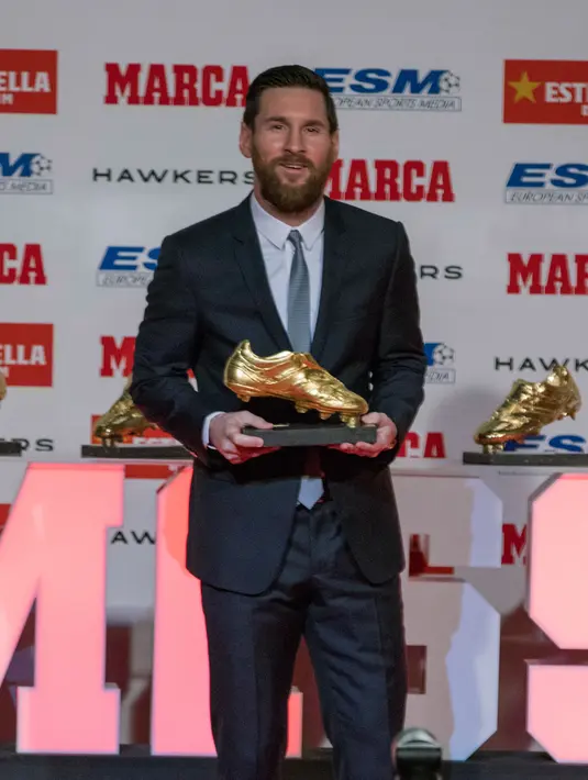 Megabintang Barcelona, Lionel Messi berpose dengan trofi Sepatu Emas Eropa kelimanya di Antiga Fabrica Estrella Damm, Selasa (18/12). Penghargaan ini diraih Messi berkat koleksi 34 gol dari 36 pertandingan di La Liga musim lalu. (AP/Joan Monfort)