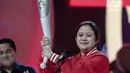Menko PMK Puan Maharani mengangkat obor untuk Asian Games 2018 saat peluncuran Torch Asian Games dalam Konser 100 Hari Menuju Asian Games 2018 di Studio 6 Emtek, Jakarta, Kamis (10/5). (Liputan6.com/Faizal Fanani)