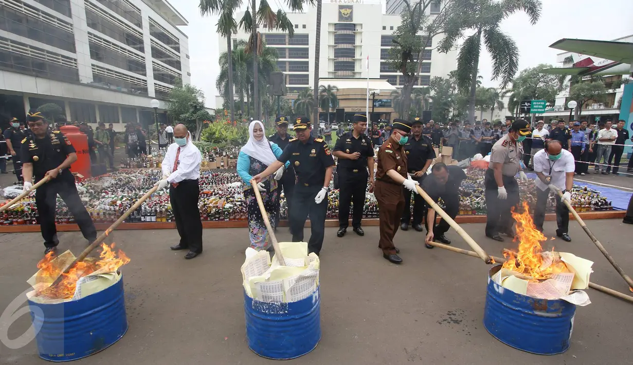 Petugas membakar barang hasil sitaan di Kantor Pusat Bea Cukai, Jakarta, Senin (20/6). Bea Cukai memusnahkan botol miras ilegal, pita cukai MMEA impor palsu, hasil tembakau serta barang larangan dan pembatasan kiriman pos. (Liputan6.com/Immanuel Antonius)
