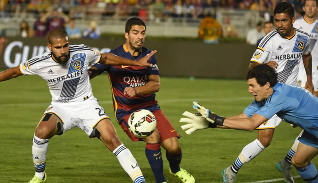 Kiper LA Galaxy, Brian Rowe berusaha menangkap bola dari kejaran penyerang Barcelona pada laga International Champions Cup 2015 di Rose Bowl, California, Rabu (22/7/2015). Barcelona menang 2-1 atas LA Galaxy. (AFP PHOTO/MARK RALSTON)