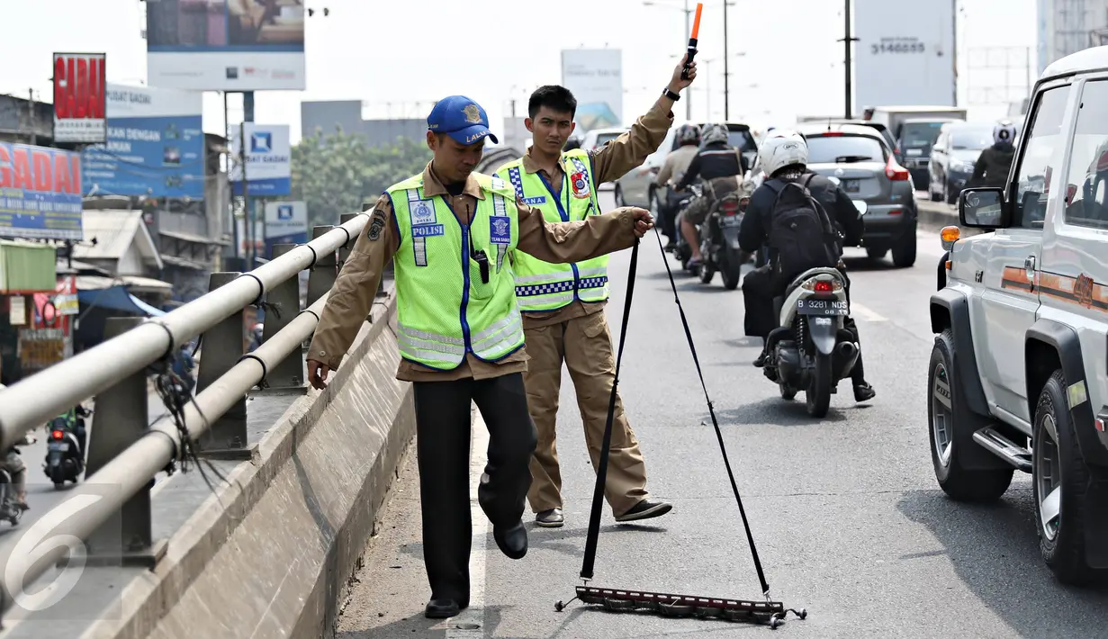 Tim Saber melakukan aksi giat sapu bersih ranjau paku di Jalan Kyai Tapa, Jakarta, Jumat (6/11). Kegiatan itu untuk membersihkan jalan dari ranjau paku dan memberikan rasa nyaman kepada para pengguna kendaraan bermotor. (Liputan6.com/Immanuel Antonius)