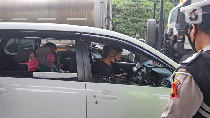 Polisi memeriksa kendaraan di Pos Penyekatan Jalur Mudik, Gerbang Tol Cikarang Barat, Bekasi, Rabu (20/5/2020). Sejak 24 April sampai 19 Mei 2020, Ditlantas Polda Metro Jaya telah memutarbalikkan 20.972 kendaraan mudik Lebaran yang hendak meninggalkan Jabodetabek. (Liputan6.com/Herman Zakharia)