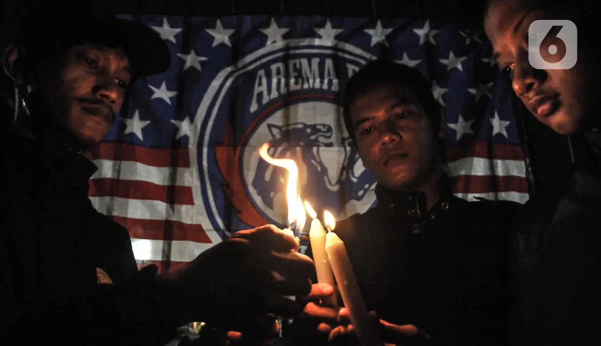 Massa yang tergabung dalam Ultras Garuda Jakarta mengikuti aksi menyalakan lilin dan tabur bunga untuk korban kerusuhan Stadion Kanjuruhan Malang di depan Stadion Gelora Bung Karno (GBK), Jakarta, Minggu (2/10/2022). Aksi tersebut sebagai aksi solidaritas antar suporter dan bentuk keprihatinan atas tragedi kerusuhan suporter sepak bola di Stadion Kanjuruhan Malang. (merdeka.com/Iqbal S Nugroho)