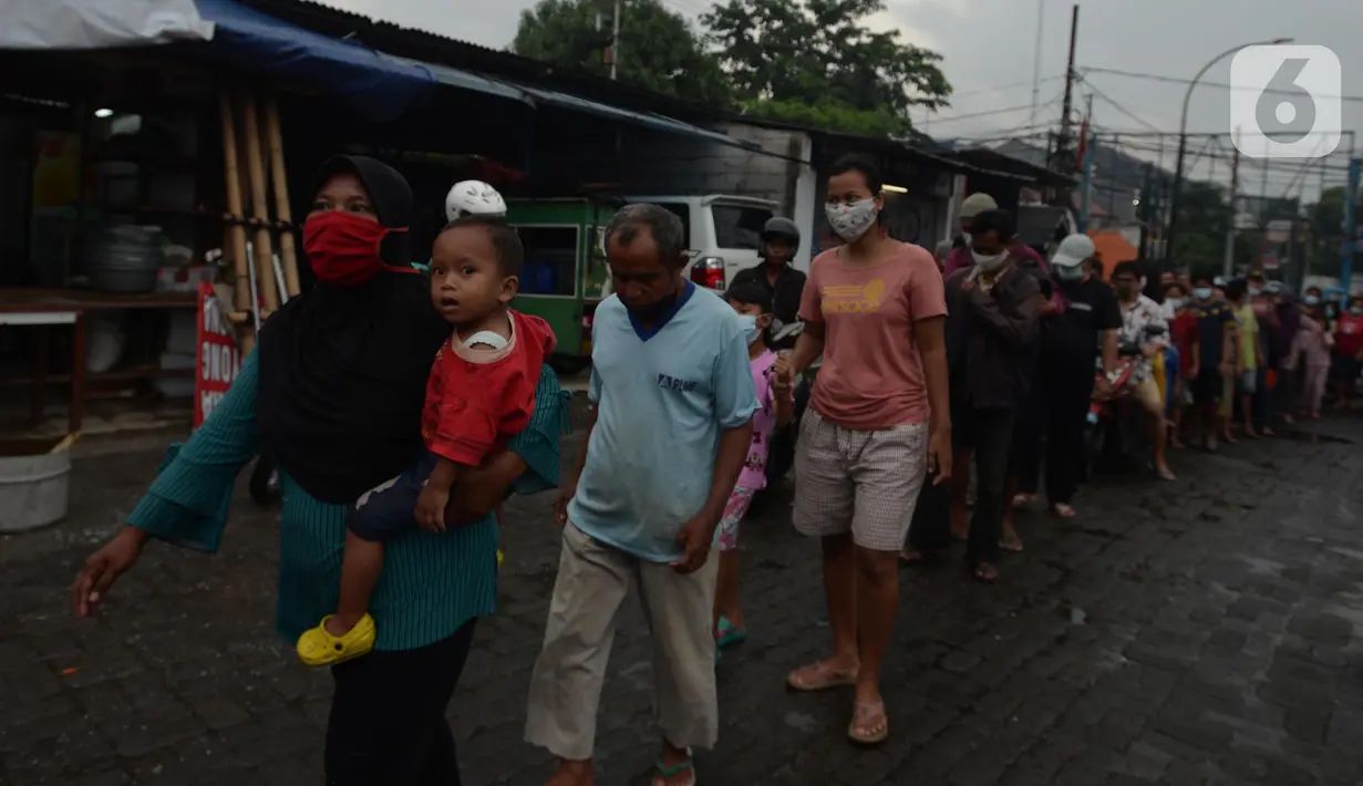 Warga mengantre menerima pembagian makan gratis di Posko Perjuangan Rakyat (POSPERA), Jakarta, Rabu (10/3/2021). Pembagian 500 nasi bungkus beserta masker dan vitamin secara gratis setiap harinya dalam bentuk meringankan beban warga di tengah pandemi Covid-19. (merdeka.com/Imam Buhori)