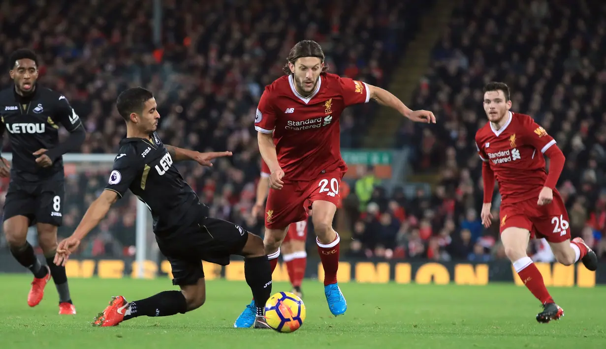 Pemain Liverpool, Adam Lallana berebut bola dengan pemain Swansea City, Kyle Naughton pada laga pekan ke-20 Premier League di Stadion Anfield, Rabu (27/12). Di hadapan suporternya sendiri, Liverpool mencukur Swansea City 5-0. (Peter Byrne/PA via AP)