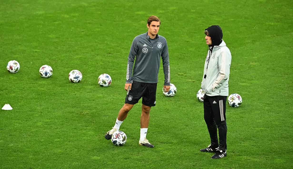 Gelandang Jerman Florian Neuhaus dan pelatih Jerman Joachim Loew (kanan) berbicara selama sesi latihan di stadion Rheinenergie, Jerman (9/10/2020). Jerman akan bertanding melawan Turki pada laga persahabatan di stadion Rheinenergie di Cologne, Jerman, Kamis (8/10/2020). (AFP/Ina Fassbender)