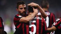 Pemain AC Milan, Giacomo Bonaventura bersama rekan setimnya, Fabio Borini merayakan gol ke gawang Bologna dalam lanjutan pekan ke-16 Liga Italia di Stadion San Siro, Senin (11/12). AC Milan menang tipis 2-1 atas Bologna. (AFP PHOTO / MARCO BERTORELLO)