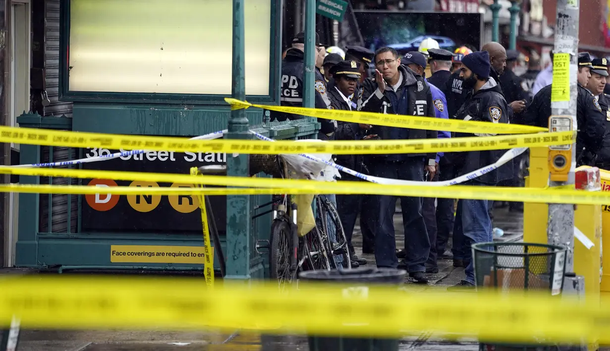 Personel Departemen Kepolisian Kota New York berkumpul di pintu masuk halte kereta bawah tanah di wilayah Brooklyn, New York, Amerika Serikat, 12 April 2022. Sejumlah orang terluka dalam penembakan yang terjadi pada jam sibuk. (AP Photo/John Minchillo)