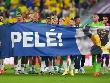Para pemain Brasil membentangkan spanduk dukungan untuk Pele yang sedang sakit pada akhir pertandingan sepak bola babak 16 besar Piala Dunia 2022 antara Brasil dan Korea Selatan di Stadium 974, Doha, Qatar, 5 Desember 2022. (AP Photo/Jin-Man Lee)