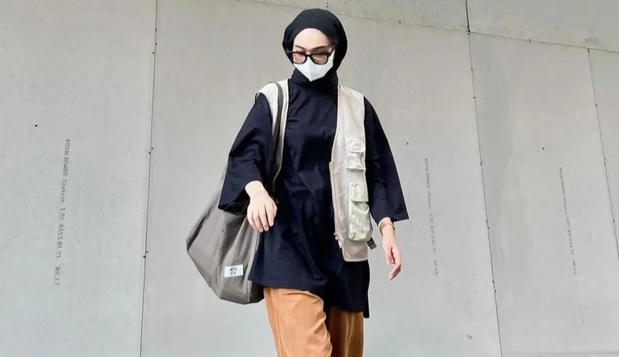 Tampilan boyish selebgram Clara ini bisa jadi inspirasi. Padukan oversized t-shirt dengan vest warna krem dan celana jogger warna coklat. (Instagram/carayaaa_).