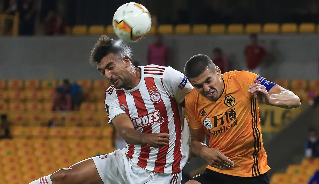 Bek Wolverhampton Wanderers, Conor Coady, berebut bola dengan striker Olympiacos, Ahmed Hassan, pada laga leg kedua babak 16 besar Liga Europa 2019/2020 di Molineux Stadium, Jumat (7/8/2020) dini hari WIB. Wolverhampton menang 1-0 atas Olympiacos. (AFP/Lindsey Parnaby)