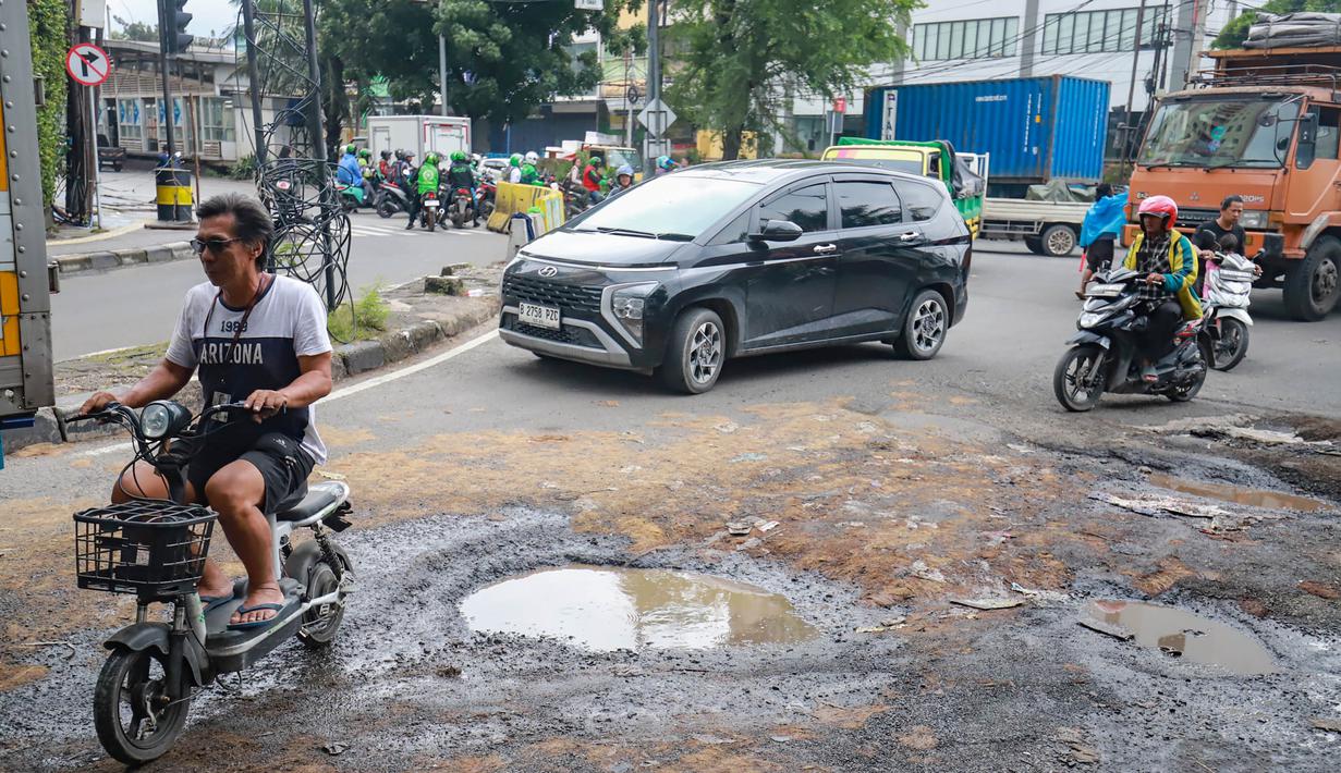 Pengendara menghindari kerusakan di Jalan Mitra Bahari, Penjaringan Jakarta Utara, Selasa (03/02/2026). Tingginya curah hujan yang mengguyur Jakarta berimbas pada rusaknya sejumlah ruas jalan. (merdeka.com/Arie Basuki)