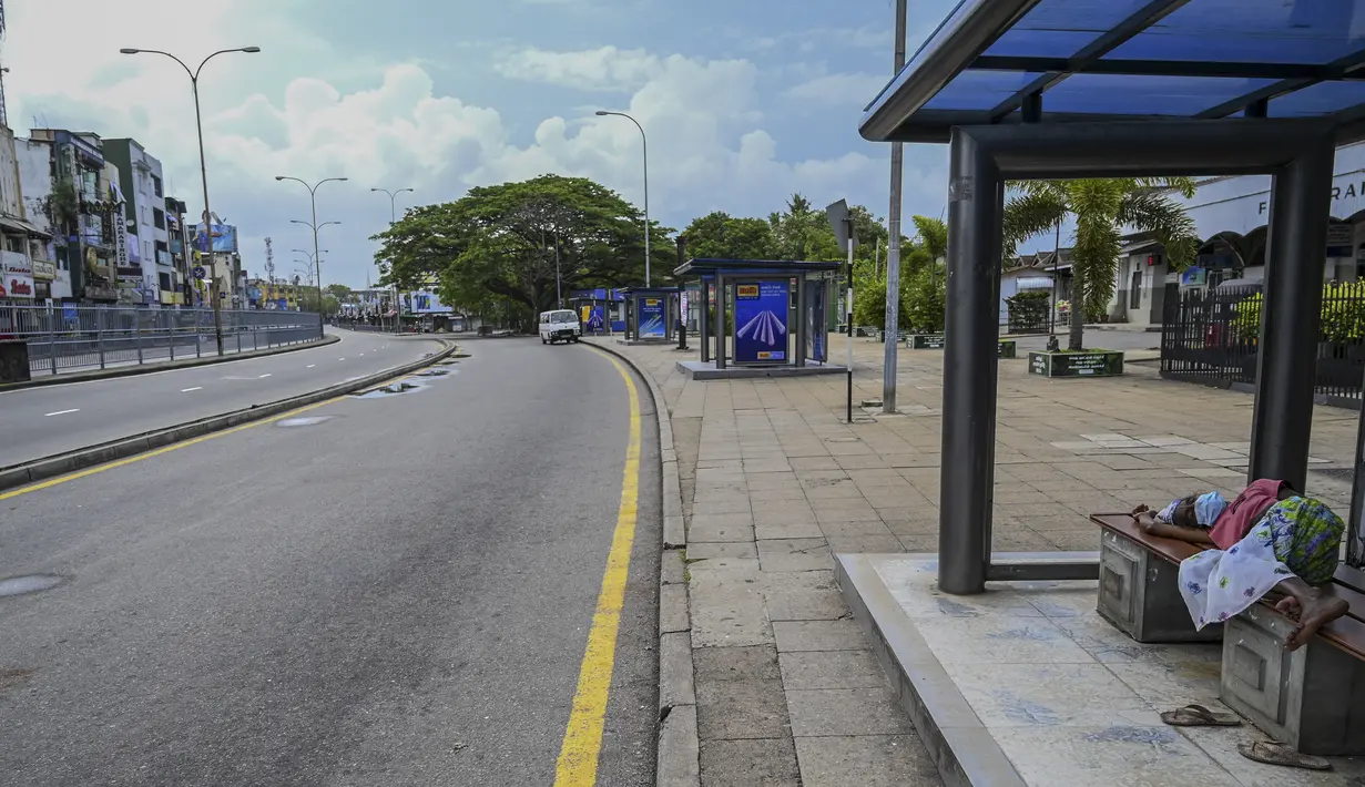 Seorang tunawisma tidur di sepanjang pinggir jalan setelah pemerintah memberlakukan pembatasan perjalanan dan lockdown akhir pekan di Kolombo, Sri Lanka, Sabtu (22/5/2021). Sri Lanka pada Jumat, 21 Mei mencatat 3.547 kasus harian corona Covid-19. (Ishara S. KODIKARA/AFP)