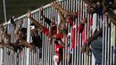 Suporter Persipura memberi dukungan kepada timnya dari pagar besi pada lanjutan Piala Jenderal Sudirman grup E  di Stadion Sleman, Yogyakarta, Minggu (13/12/2015). (Bola.com/Nicklas Hanoatubun)