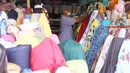 Pedagang menata kain dagangan di Pasar Cipadu, Tangerang, Selasa (2/3/2021). Pandemi Covid-19 membuat industri tekstil dan pakaian jadi mengalami pertumbuhan negatif 8, 8% sepanjang 2020, bahkan pandemi membuat tenaga kerja di sektor industri tekstil berkurang hingga 13%. (Liputan6.com/Angga Yuniar)