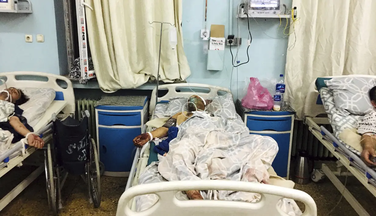 Warga Afghanistan berbaring di tempat tidur di sebuah rumah sakit setelah mereka terluka dalam serangan mematikan di luar bandara di Kabul, Afghanistan, Kamis (26/8/2021). (AP Photo/Mohammad Asif Khan)