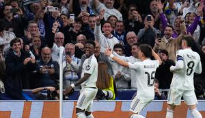 Pemain Real Madrid, Vinicius Junior (kiri), merayakan gol kedua bersama rekan setimnya dalam leg kedua play-off Liga Champions melawan Benfica di Santiago Bernabeu, Kamis (26/2/2026) dini hari WIB. (AP Photo/Manu Fernandez)