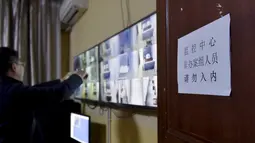 Petugas mengamati kamar tahanan melalui monitor di Chengdu, China, 10 Desember 2015. Penjara khusus para terduga koruptor ini didesain dengan ditambah busa pada setiap dinding untuk memberi kenyamanan dan mencegah tahanan bunuh diri. (REUTERS)