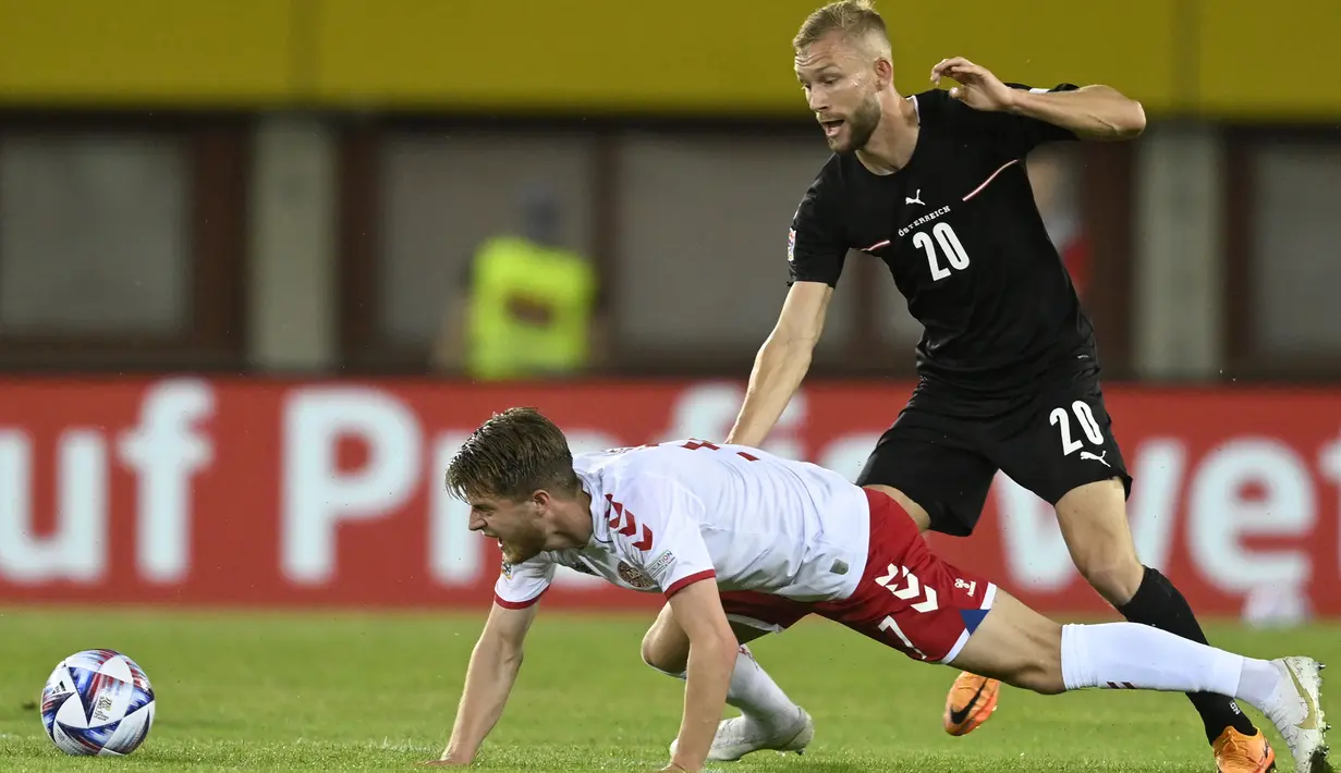 <p>Gelandang Austria, Konrad Laimer berebut bola dengan pemain Denmark, Joakim Mahle pada pertandingan UEFA Nations League di Stadion Ernst Happel di Wina, Austria, Selasa (7/6/2022). Denmark menang tipis atas Austria 2-1. (AP Photo/Andreas Schaad)</p>