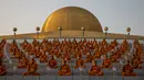 Biksu Buddha menghadiri perayaan Makha Bucha di tengah pandemi COVID-19, di Wat Dhammakaya, Bangkok, Jumat (26/2/2021). Perayaan Makha Bucha merupakan upacara keagaamaan terbesar di Thailand. Pada perayaan itu, warga Buddha bersembahyang dan memberikan sedekah kepada para biksu. (Jack TAYLOR/AFP)