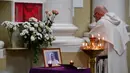 Ekspresi seorang anggota rohaniwan di depan potret Paus Fransiskus di salah satu Gereja Katolik, Saint Petersburg pada Senin (21/4/2025). (Olga MALTSEVA/AFP)