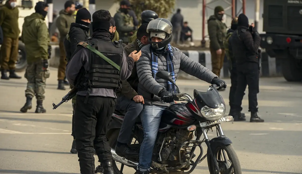 Pasukan Special Operation Group (SOG) menghentikan pengendara sepeda motor selama pencarian acak terhadap orang-orang di Srinagar, kota terbesar di Kashmir, Jumat (21/1/2022). Peningkatan keamanan dilakukan menjelang Hari Republik India pada 26 Januari mendatang. (TAUSEEF MUSTAFA / AFP)