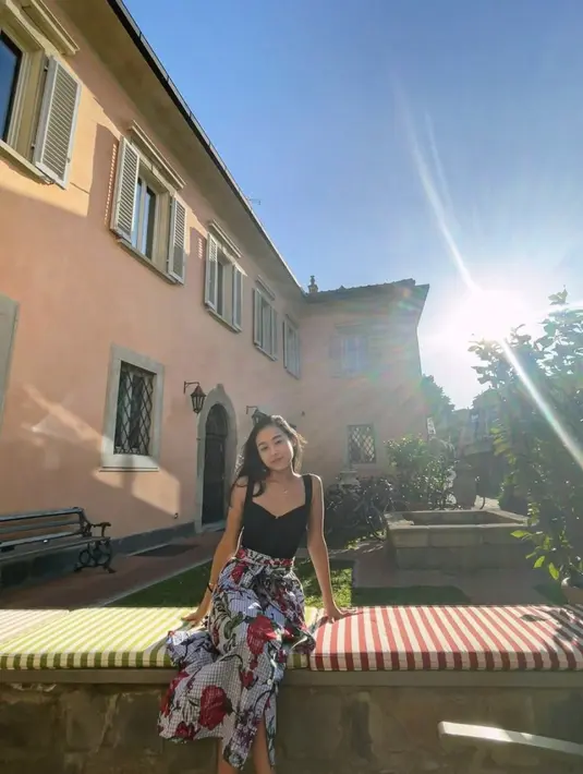 Berlibur ke Italia, Dhika kenakan maxi dress dengan aksen floral yang glamor.  [Foto: Instagram/ Dhika Himawan]