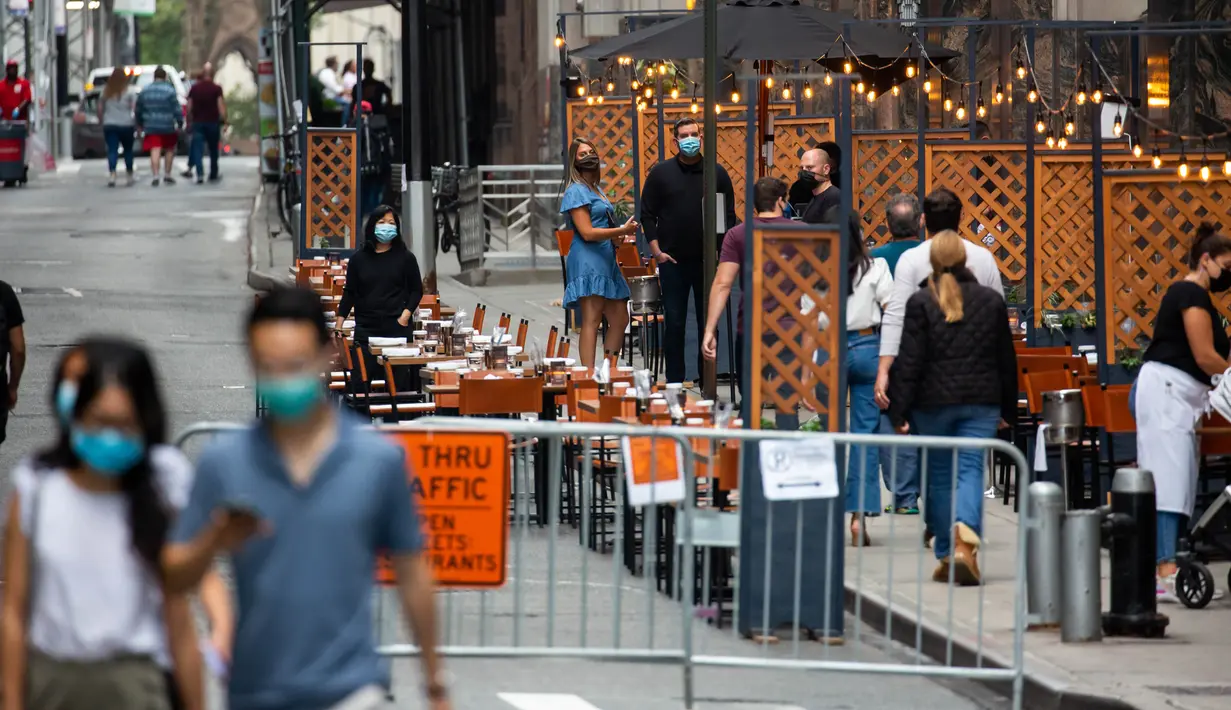 Para pejalan kaki yang memakai masker berjalan melewati tempat makan terbuka di Distrik Keuangan, New York, Amerika Serikat, 25 September 2020. Hingga 25 September 2020, sebanyak 7.005.746 orang di Amerika Serikat terinfeksi COVID-19, dengan 203.240 orang meninggal dunia. (Xinhua/Michael Nagle)