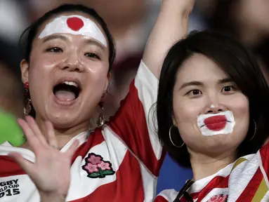 Dua fans wanita dengan wajah di cat bendera Jepang bersorak sebelum pertandingan melawan Rusia pada pembukaan Rugby World Cup Pool A  di Stadion Tokyo (20/9/201). Rugby World Cup diselenggarakan dari 20 September hingga 2 November 2019. (AP Photo/Jae Hong)