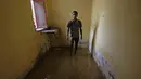 Seorang pemuda Sudan berdiri di dalam ruangan banjir di daerah alqamayir di kota kembar ibu kota Omdurman (26/8/2020). (AFP Photo/Ashraf Shazly)